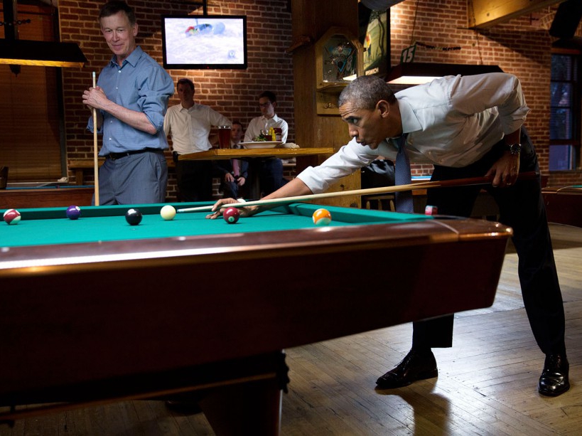 President Barack Obama whistles along to the music as he shoots pool with Gov. John Hickenlooper, D-Colo. in Denver, Colo., July 8, 2014. (Official White House Photo by Pete Souza) This official White House photograph is being made available only for publication by news organizations and/or for personal use printing by the subject(s) of the photograph. The photograph may not be manipulated in any way and may not be used in commercial or political materials, advertisements, emails, products, promotions that in any way suggests approval or endorsement of the President, the First Family, or the White House.